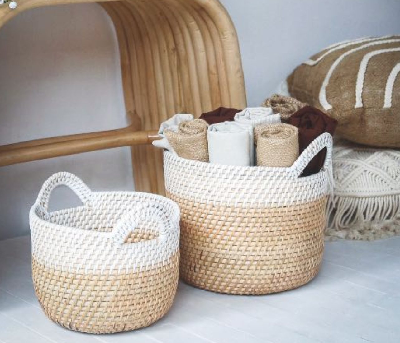 Two two-tone rattan baskets, white-washed top and natural bottom, with handles